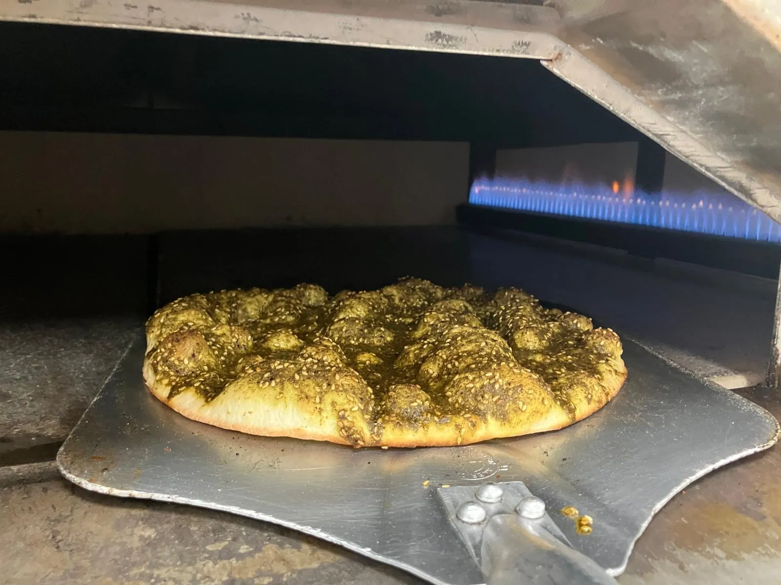 Zaatar manoushe baking in the oven at Adonis Market